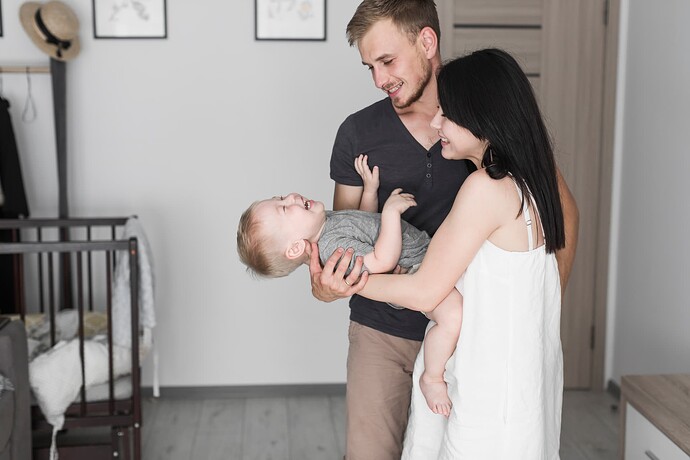 smiling-young-couple-playing-with-his-son-home